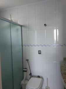 y baño con aseo y ducha acristalada. en Condominio Edificio Thaiti, en Guarujá