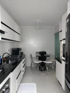 una cocina con mesa y sillas. en Condominio Edificio Thaiti, en Guarujá