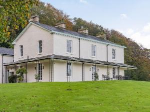 a large white house on top of a green field at Arnside View in Arnside