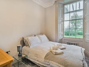 1 dormitorio con 1 cama con sábanas blancas y ventana en Arnside View, en Arnside