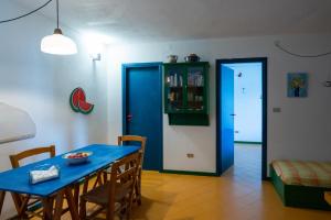 a dining room with a blue table and chairs at Scopello Villa sul Mare in Scopello