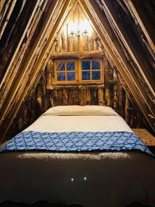 Bett in einem kleinen Zimmer mit Fenster in der Unterkunft Bosques del Paico in El Monte
