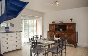 a dining room with a table and chairs and a dresser at 2 Bedroom Amazing Home In Brlidy in Brélidy