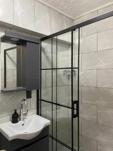 a bathroom with a sink and a glass shower at PANORAMA CITY SUITE in Istanbul