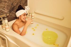 a woman in a bath tub with a towel on her head at Section L Hatchobori in Tokyo