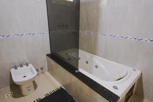 a bathroom with a sink and a toilet and a tub at Cabañas Riberas del Paraná in Puerto Iguazú