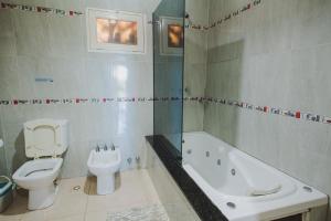 a bathroom with a toilet and a tub and a sink at Cabañas Riberas del Paraná in Puerto Iguazú