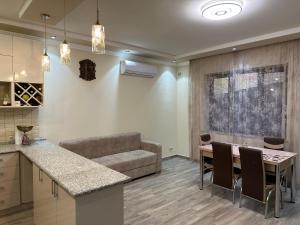 a kitchen and living room with a table and a couch at OUR House in Vagharshapat