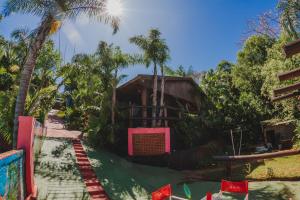 a house in the middle of a jungle with palm trees at Cabañas Riberas del Paraná in Puerto Iguazú