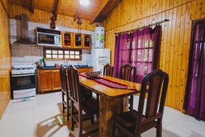 a kitchen with a wooden table and chairs at Cabañas Riberas del Paraná in Puerto Iguazú