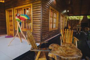 a wooden cabin with a parrot sitting on a chair at Cabañas Riberas del Paraná in Puerto Iguazú