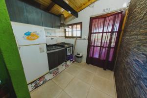 a small kitchen with a refrigerator and a sink at Cabañas Riberas del Paraná in Puerto Iguazú
