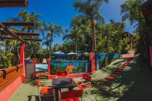 a pool with colorful chairs and a man in the water at Cabañas Riberas del Paraná in Puerto Iguazú