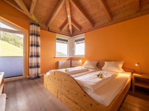 Schlafzimmer mit einem Holzbett mit weißer Bettwäsche in der Unterkunft Sonnenwinkel III in Kolsassberg