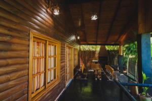 a porch of a wooden cabin with a table and chairs at Cabañas Riberas del Paraná in Puerto Iguazú