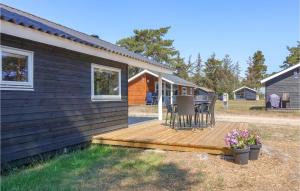 a wooden deck with a table and chairs on a house at Gorgeous Home In Nex With Kitchen in Neksø