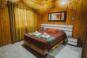 ein Schlafzimmer mit einem Bett mit zwei Handtüchern darauf in der Unterkunft Cabañas Riberas del Paraná in Puerto Iguazú