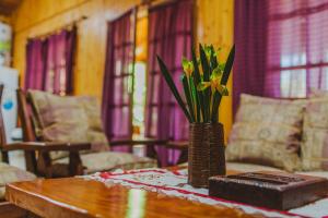 a wooden table with a vase with flowers on it at Cabañas Riberas del Paraná in Puerto Iguazú