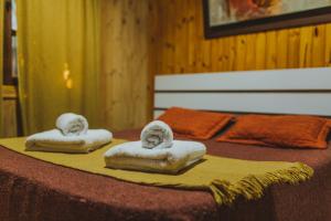 two towels with faces on them sitting on a bed at Cabañas Riberas del Paraná in Puerto Iguazú