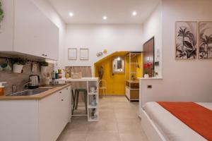een keuken en een slaapkamer met een bed en een wastafel bij Santalucia 36 in Napels