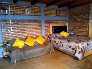 a bedroom with two beds and a couch at CABAÑA Adán y Eva en Zacatlán in Zacatlán