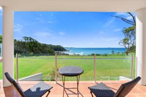 a view from the balcony of a house with a table and chairs at Villa Provence Coffs Harbour in Coffs Harbour