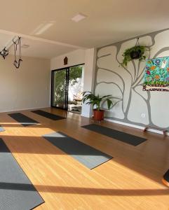 una sala de yoga con alfombras en el suelo y un mural de árboles en Guest room Casa SEA en Florianópolis