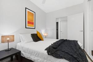 - une chambre blanche avec un lit et une couverture dans l'établissement 108 Astral Apartments, à Melbourne