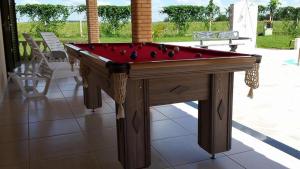 a pool table with a red top on a patio at Recanto Vale do Sol in Olímpia
