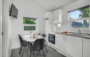 a white kitchen with a small table and chairs at Stunning Home In Assens With Kitchen in Assens