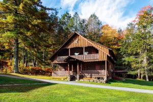 a large wooden cabin in the middle of a forest at Urban Cowboy Lodge in Big Indian