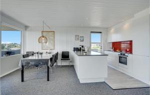 une cuisine avec des placards blancs et une table avec des chaises dans l'établissement 3 Bedroom Awesome Home In Hejls, à Hejls