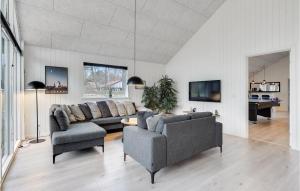 a living room with two couches and a table at Stunning Home In Væggerløse With Sauna in Marielyst