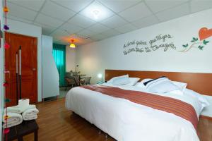 - une chambre avec un grand lit et un panneau mural dans l'établissement Magic Cusco Suites, à Cusco