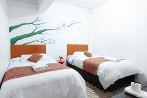 - 2 lits dans une chambre ornée d'une peinture murale dans l'établissement Magic Cusco Suites, à Cusco