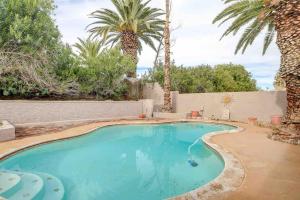 una piscina in un cortile con palme di Resort Style 4BR House with Pool Min from Strip a Las Vegas