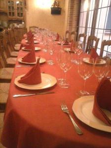 una mesa larga con copas de vino y servilletas. en Hotel Rural El Museo en Cedillo de la Torre