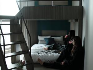 two women sitting on a bed in a loft at FAV TOKYO Nishinippori in Tokyo