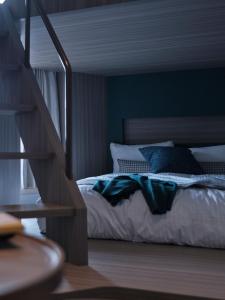 a bedroom with a bed with blue walls and a staircase at FAV TOKYO Nishinippori in Tokyo