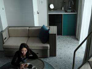 a woman sitting at a table in a living room at FAV TOKYO Nishinippori in Tokyo