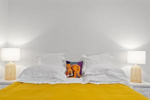 a bed with white sheets and pillows on it at Top of the town in Bangalow