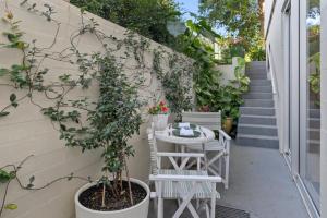 a small patio with a table and chairs and a plant at Top of the town in Bangalow