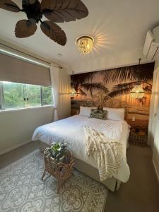 a bedroom with a large bed and a ceiling fan at Airlie Summit Apartments in Airlie Beach