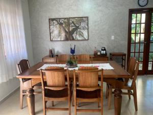 a dining room with a wooden table and chairs at Casa Laranja Lençóis - BA in Lençóis