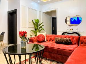 - un salon avec un canapé rouge et une table en verre dans l'établissement ALEXANDRIA COURT, à Lekki