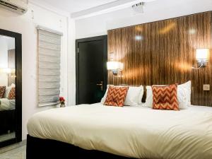 - une chambre avec un grand lit blanc et 2 oreillers dans l'établissement ALEXANDRIA COURT, à Lekki
