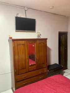 1 dormitorio con TV en la parte superior de un armario de madera en Hostal THE IMPERIAL, en Quito