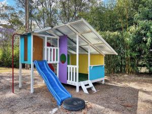 a play house with a slide and a playground at Alfie's Place in Nulkaba