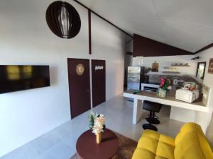 O'hale Perry في Pirae: غرفة معيشة مع أريكة صفراء ومطبخ