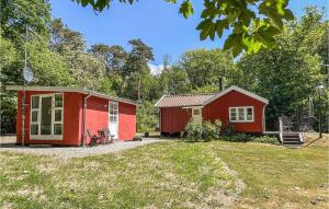 a red house and a red cottage in a yard at Nice Home In Rnne With Wifi in Rønne